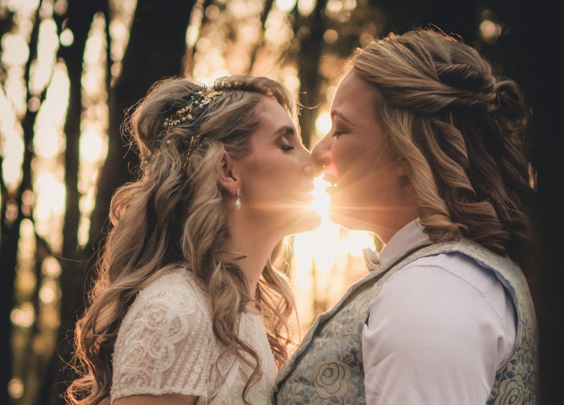 Two brides sharing a quiet moment together in warm evening light