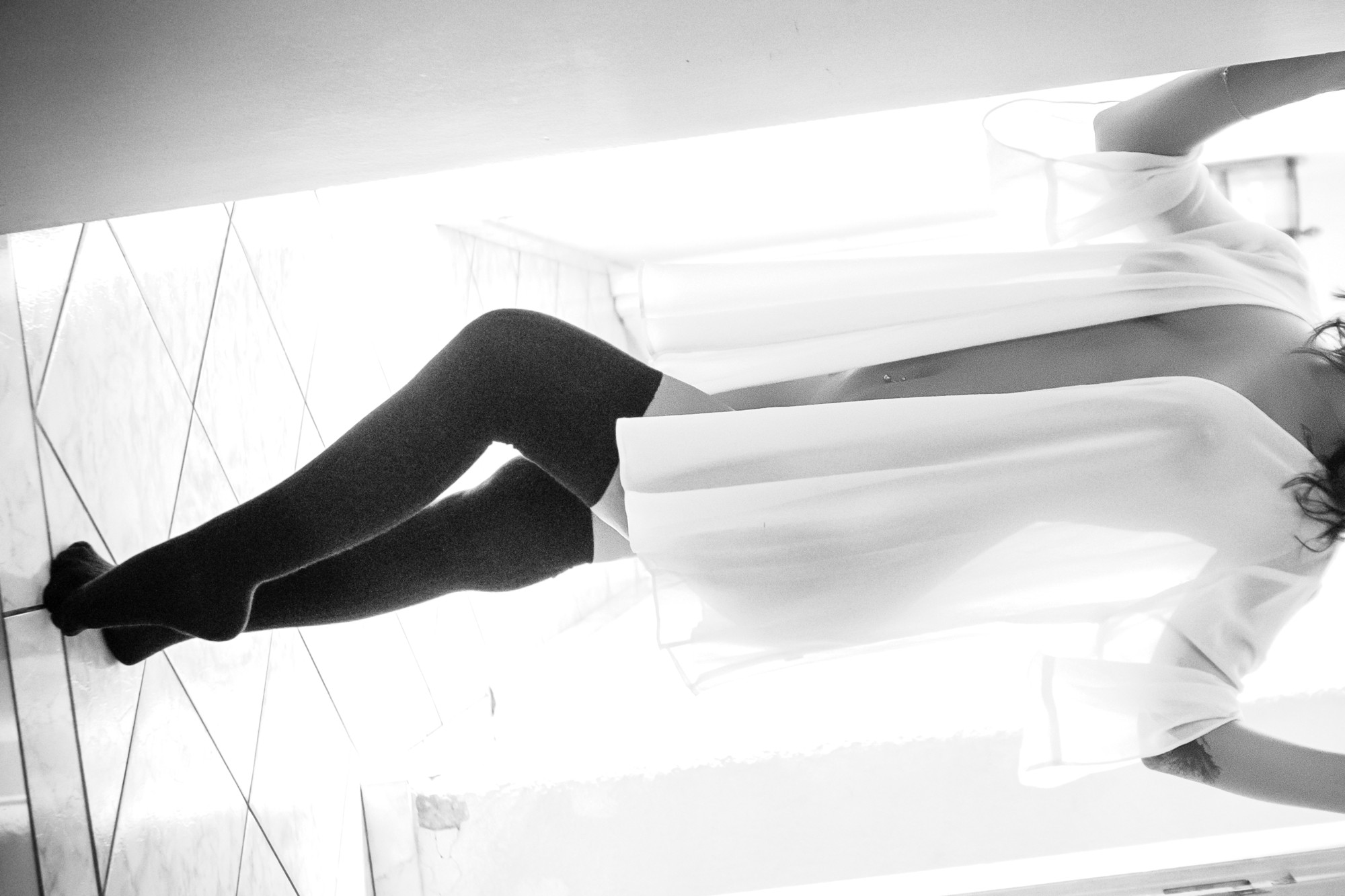 Black and white boudoir portrait in a sheer robe during a guided indoor session