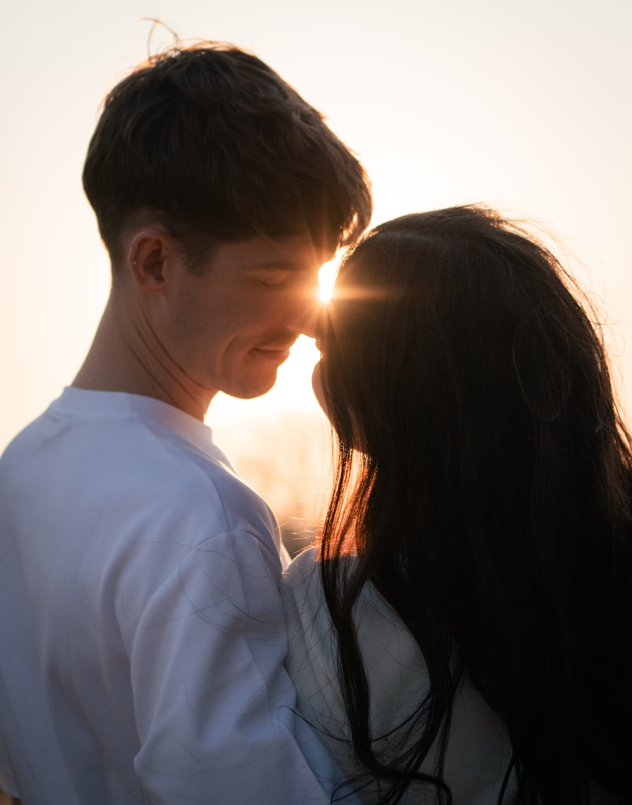 Gareth and Shannon touching foreheads with the setting sun between them