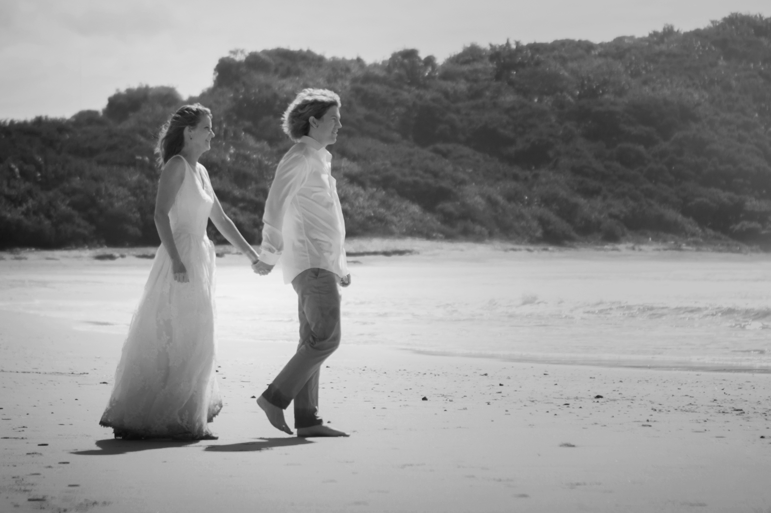 Couple walking hand in hand along the beach