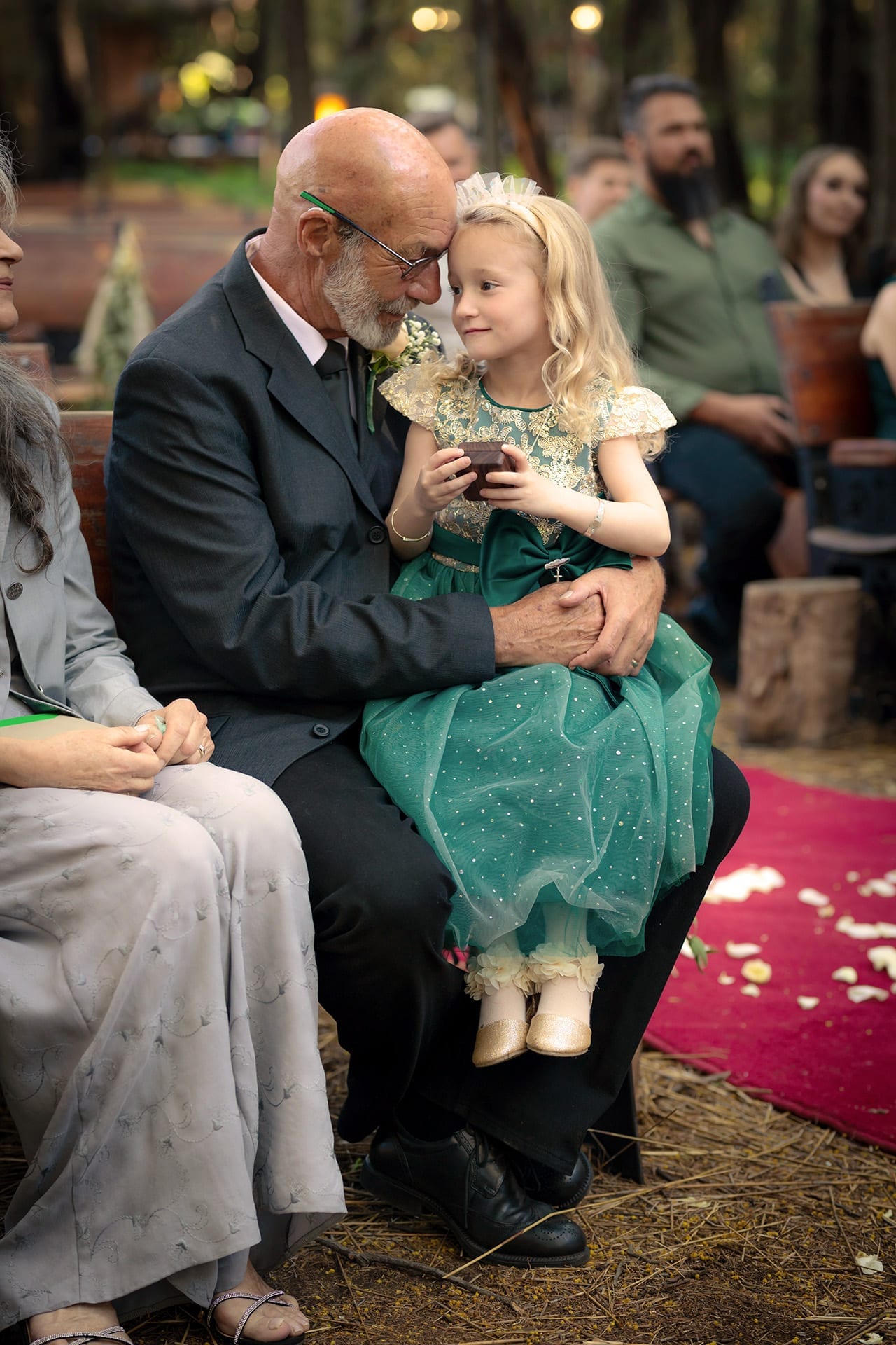 A grandfather sharing a quiet moment with his granddaughter during a wedding